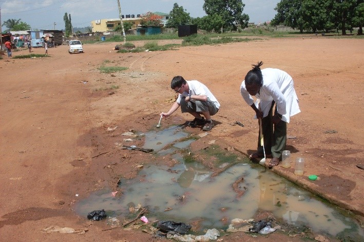 Collecting mosquito larva from pools in Ghana.