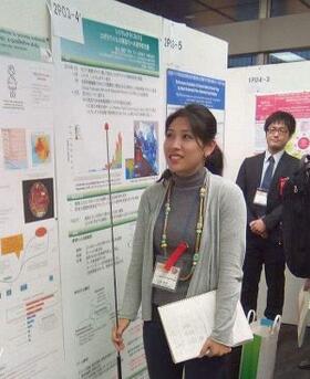 Rie Takahashi discussing her poster with delegates