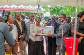 Hon. Ummy Mwalimu (MP) and Minister of Health in Tanzania handing over medical equipment to the heads of the relevant Councils on behalf of each facility. Photo Credit: UDOM