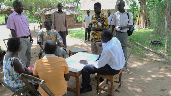 A group of people sitting around a table looking at a map.