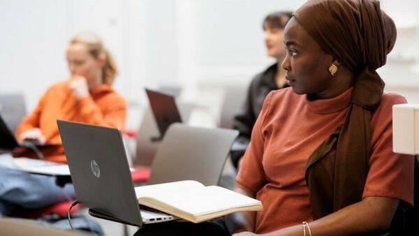 Postgraduate student in a lecture with laptop.