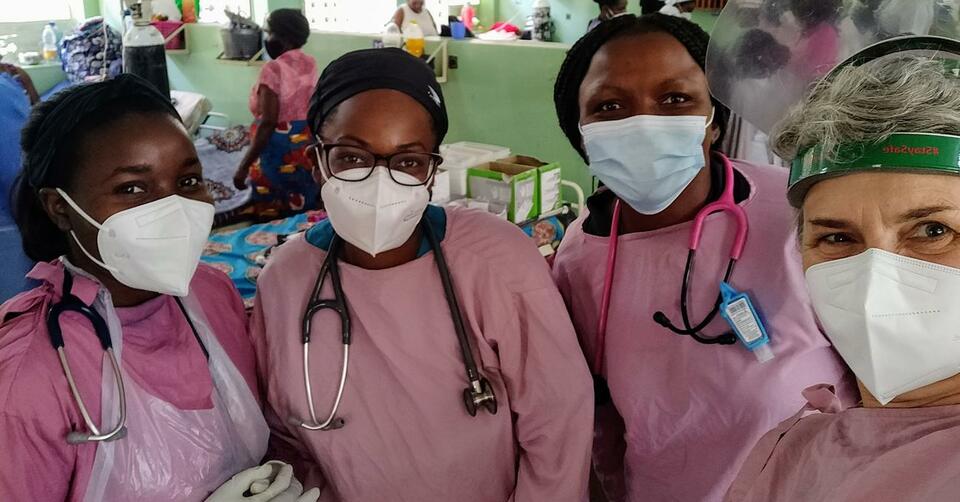 4 nurses in pink ppe standing in a hospital ward in Malawi