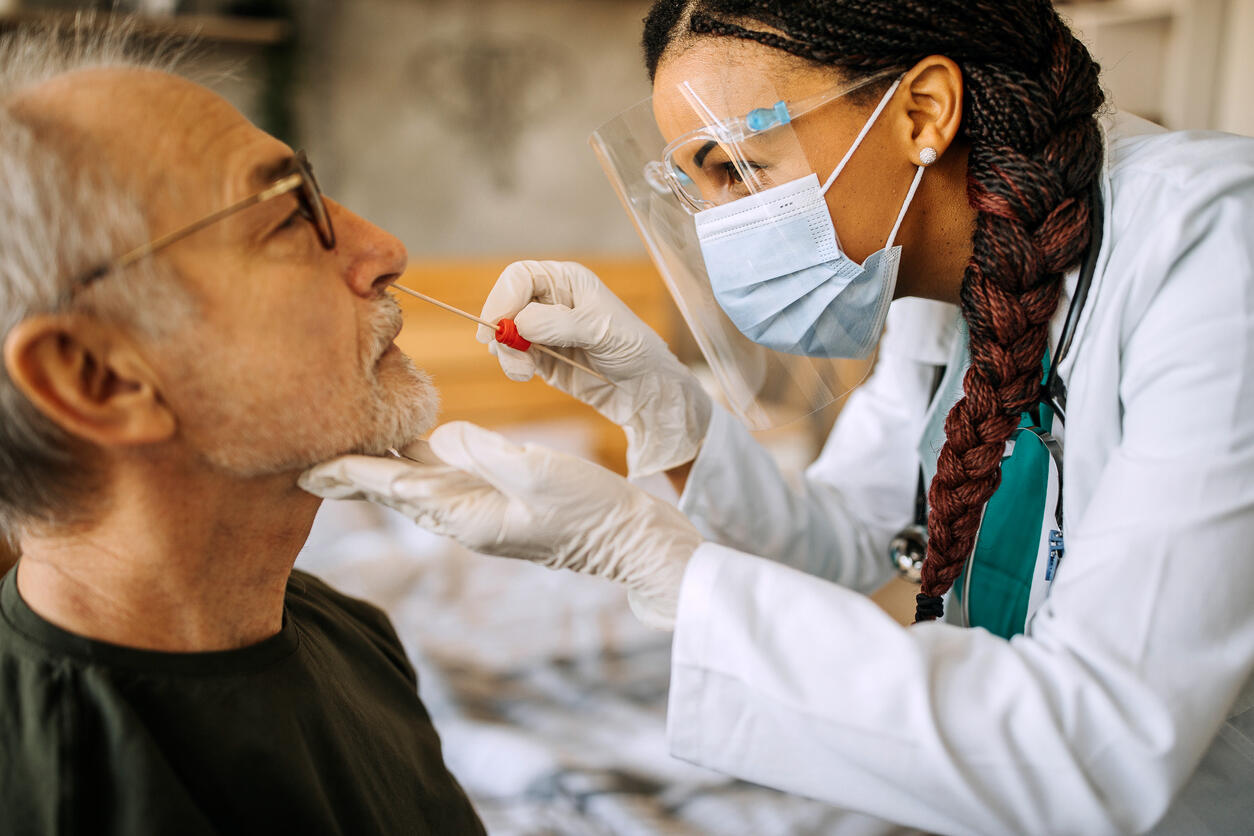 Clinician taking nasal swab from patient