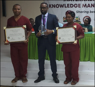 Winners of Best mentor (male and female category) pause for a photo with the Medical Superintendent (Ijara Sub county hospital)  while displaying their certificates of recognition and plaque.