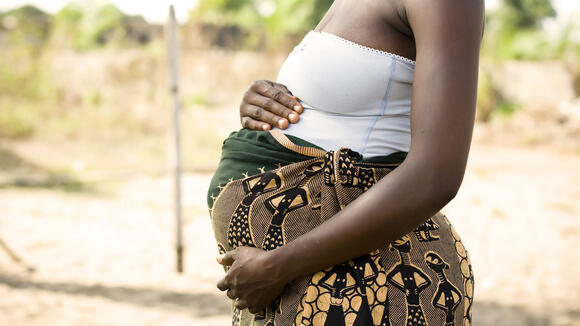A pregnant African woman holding her stomach