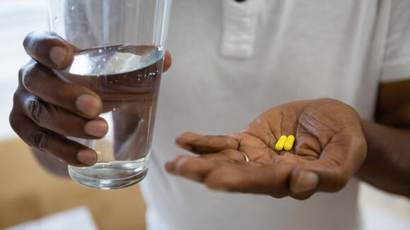 person holding medicines and drinking water